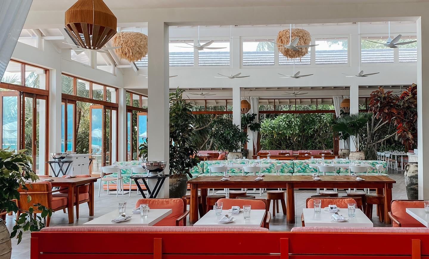Luxury hotel restaurant warm interior Warm luxury hotel restaurant interior with natural light and tropical greenery